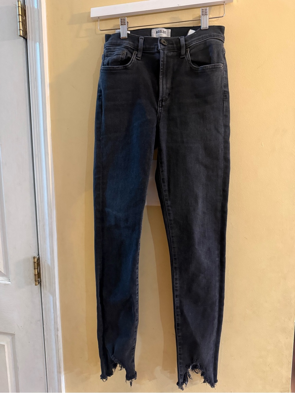 AGOLDE Sophie black skinny jeans featuring a distinct raw, frayed hem, size 24